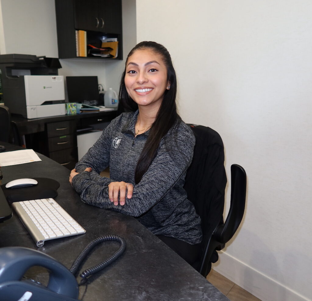 Team member at front desk smiling, First Impression Orthodontics in Alexandria VA